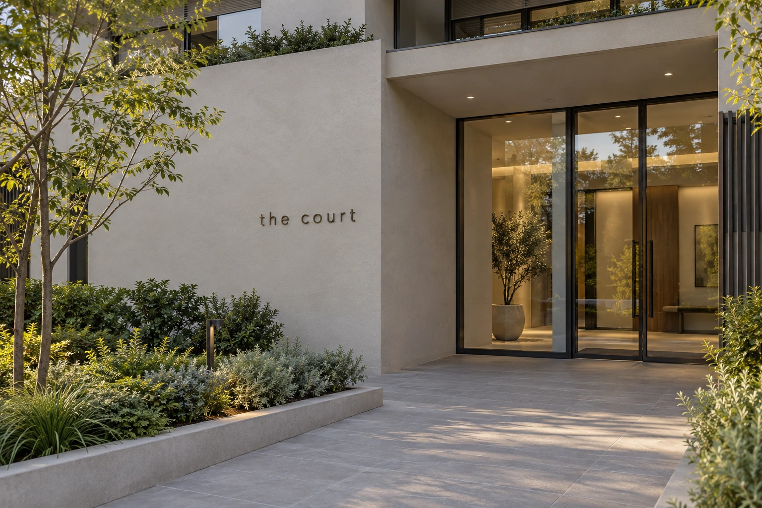 Illustrative building facade sign: small slim bronze letters on a residential entrance wall